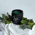 Alpine Lift premium scented candle by Ivy’s House with ivy leaves on soft white fabric