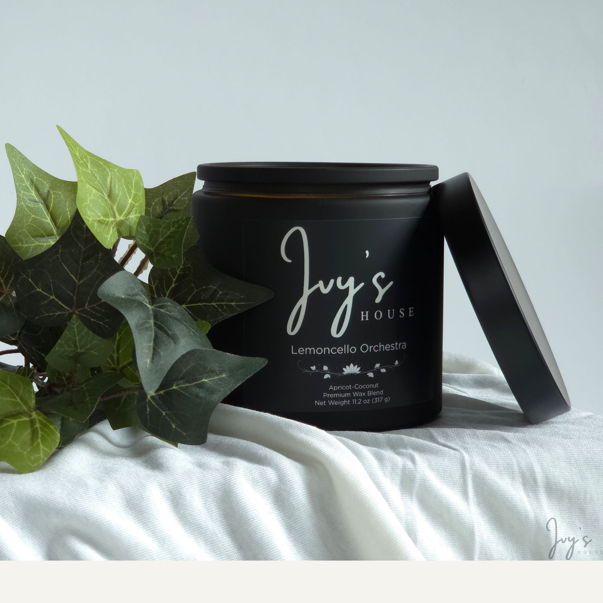 Lemoncello Orchestra premium scented candle by Ivy’s House with ivy leaves on soft white fabric