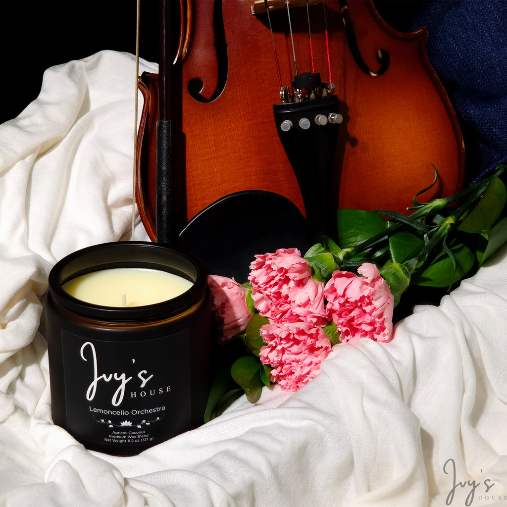 Lemoncello Orchestra candle by Ivy’s House with violin and pink flowers on soft fabric