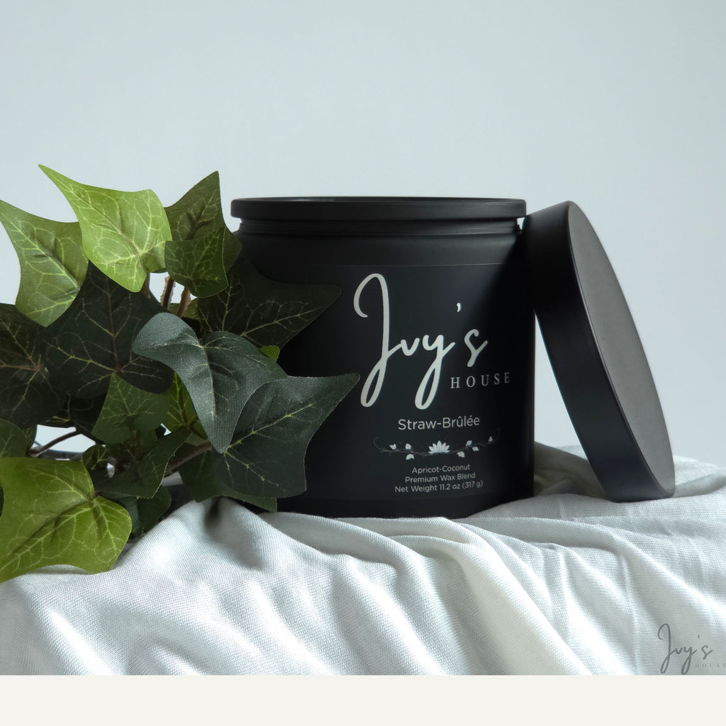 Straw-Brûlée premium scented candle by Ivy’s House with ivy leaves on soft white fabric