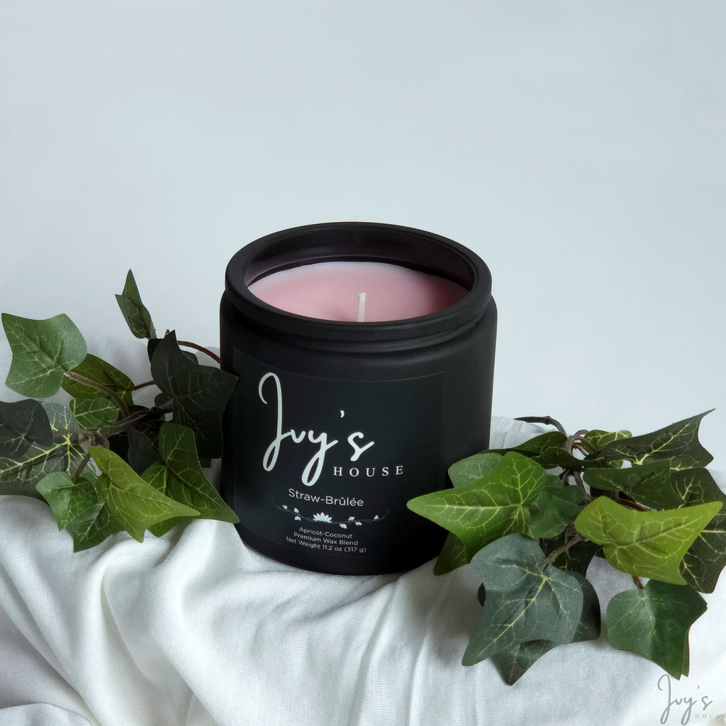 Straw-Brûlée premium scented candle by Ivy’s House with ivy leaves on soft white fabric